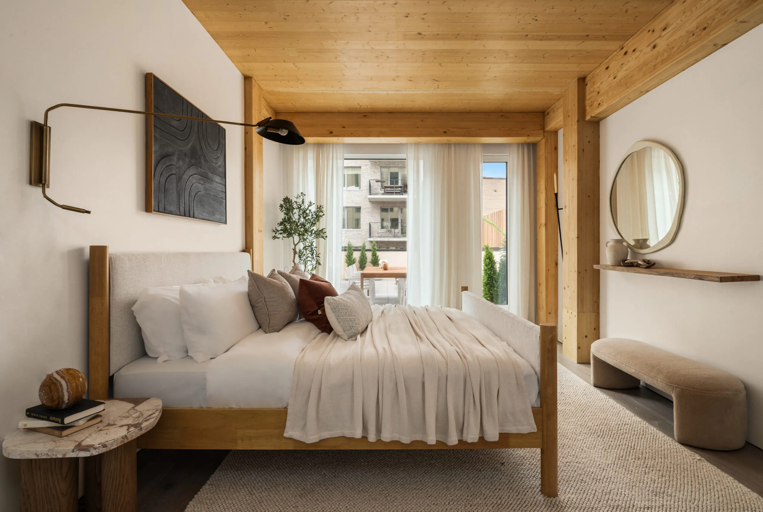 Bedroom at Timberburg in New York City, featuring exposed wood ceilings and structural timber columns surrounding a furnished sleeping area.